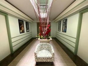 a hallway with a chair and a vase with flowers at Hollywood Celebrity Hotel in Los Angeles