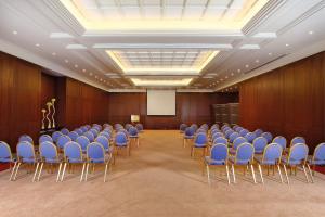 a conference room with blue chairs and a podium at InterContinental Mzaar Lebanon Mountain Resort & Spa by IHG in Kfardebian +121 photos