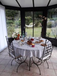 einen Tisch mit einem weißen Tischtuch und Essen drauf in der Unterkunft à l'orée du bois in Bois-Jérôme-Saint-Ouen