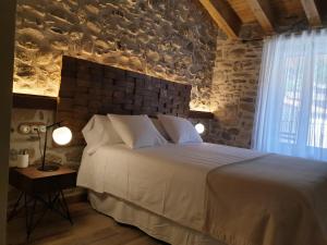 a bedroom with a large bed and a brick wall at Sports House Nord Sud (Only Adults) in Vilallonga de Ter