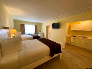 a hotel room with two beds and a kitchen at Hollywood Celebrity Hotel in Los Angeles