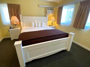 a bedroom with a large white bed with two night stands at Hollywood Celebrity Hotel in Los Angeles