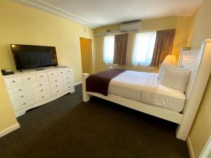 a bedroom with a bed and a flat screen tv at Hollywood Celebrity Hotel in Los Angeles