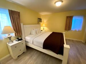a bedroom with a large bed and two windows at Hollywood Celebrity Hotel in Los Angeles