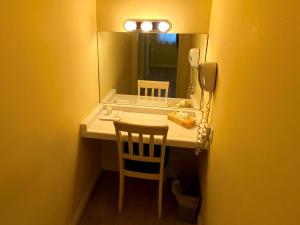 a desk with a mirror and a chair and a phone at Hollywood Celebrity Hotel in Los Angeles