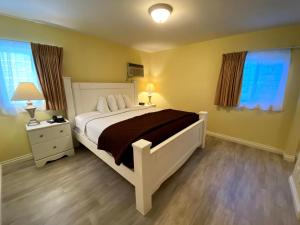 a bedroom with a large white bed and two windows at Hollywood Celebrity Hotel in Los Angeles