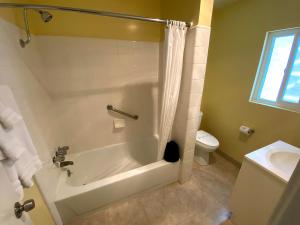 a white bathroom with a tub and a toilet at Hollywood Celebrity Hotel in Los Angeles