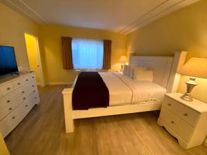 a bedroom with a white bed and a television at Hollywood Celebrity Hotel in Los Angeles