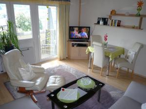 a living room with a table and chairs and a television at Pension / FW Gästehaus Stern in Bodenmais
