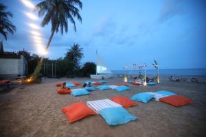 eine Gruppe von Menschen, die am Strand mit Sonnenschirmen liegen in der Unterkunft Dhevan Dara Beach Villa Kuiburi in Kui Buri