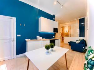 a living room with a white table and a blue wall at Suite Bayle - Standing - Hyper centre in Montpellier