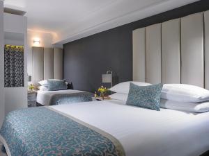 a hotel room with two beds with blue and white pillows at Asgard Apartments in Westport