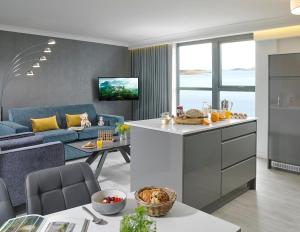 cocina y sala de estar con sofá azul en Asgard Apartments en Westport