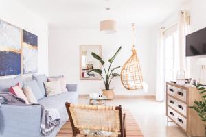 ein Wohnzimmer mit einem blauen Sofa und einer Topfpflanze in der Unterkunft Lovely&Sunny Apartament Near Poris Beach in Santa Cruz de Tenerife