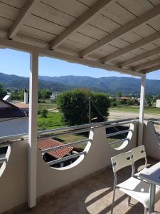 a balcony with chairs and a view of the mountains at ANGEL STUDIOS in Nea Vrasna