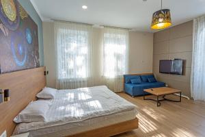 a bedroom with a bed and a blue couch at Koisha in Bishkek