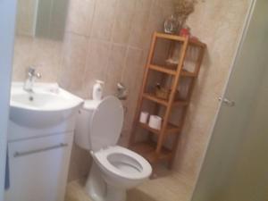 ein Badezimmer mit einem weißen WC und einem Waschbecken in der Unterkunft Georgia's House in Paphos City