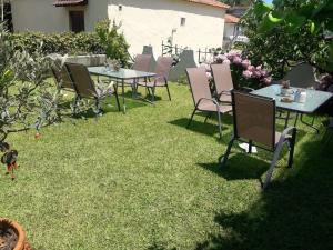 a group of tables and chairs sitting on the grass at ANGEL STUDIOS in Nea Vrasna