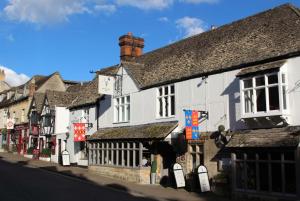 een rij gebouwen aan een stadsstraat bij The White Hart Inn in Winchcombe