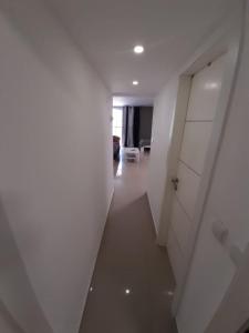 a hallway with a white wall and a door at דירות נופש וג'קוזי באילת - אילן vip in Eilat