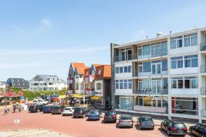 a city street with cars parked in a parking lot at Aan Zee in Bergen aan Zee