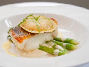 a white plate of food with fish and asparagus at Montcalm Brewery Townhouse in London