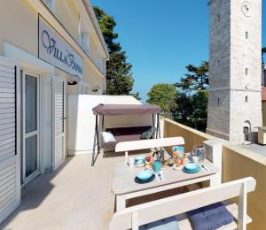 eine Terrasse mit einem Tisch und einem Stuhl auf dem Balkon in der Unterkunft STELLA deluxe SUPERIOR 5 star apartment, your piece of heaven by the sea & park, with sea view in Novigrad Istria