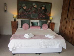 a bedroom with a bed and a painting on the wall at Dio Dell Amore Guest House in Jeffreys Bay