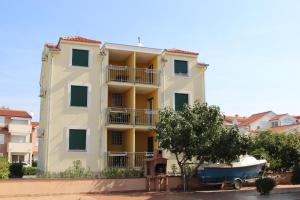 a building with a boat parked in front of it at Apartments Marina in Vodice