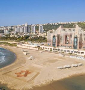 an aerial view of a beach with buildings and the ocean at Marom Apartments Hof Hacarmel in Haifa