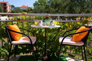a table with orange pillows sitting on a balcony at Apartments Vinka in Sveti Filip i Jakov