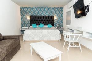 a bedroom with a bed and a couch and a table at Hotel Kyrios Veracruz in Veracruz