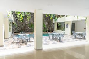 a patio with tables and chairs and a pool at Grand Hotel KYRIOS Veracruz in Veracruz