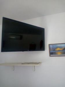 ein Flachbildfernseher an einer Wand mit einem Regal in der Unterkunft edera in Vaslui