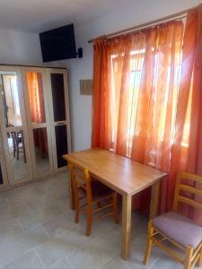ein Esszimmer mit einem Holztisch und zwei Stühlen in der Unterkunft edera in Vaslui