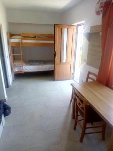 ein Zimmer mit einem Tisch und ein Zimmer mit Etagenbetten in der Unterkunft edera in Vaslui