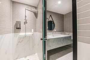 uma casa de banho com um chuveiro e um lavatório. em Brown Dot Hotel Ulsan Jangsaengpo em Ulsan