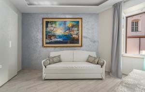 a white couch in a room with a painting at Boutique Hotel Melissa in Poreč