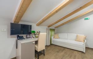 a room with a desk with a tv and a couch at Boutique Hotel Melissa in Poreč