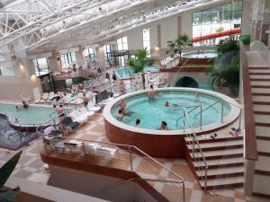 a large indoor pool in a building with people in it at Apartament 3 camere central decomandat lux in Oradea