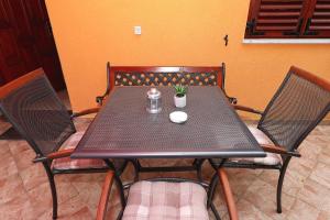 een zwarte tafel met twee stoelen en een plant erop bij Apartmani Strpić in Biograd na Moru