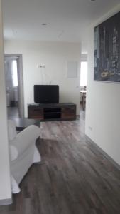 a living room with a white couch and a television at Ferienwohnung Junghanns in Kitzscher