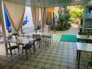un patio con mesas y sillas en un restaurante en Uyutnaya Laguna Guest House, en Loo