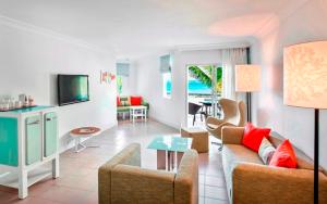 a living room filled with furniture and a kitchen at Ambre - Adults only in Belle Mare