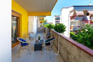 Un patio con sillas y una mesa en el balcón. en Casa Volodja a due passi dal mare, en Alba Adriatica