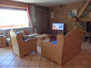 - un salon avec un canapé et une télévision dans l'établissement L'Embrune, à Tignes