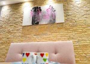 a couch in a room with a painting on a brick wall at STUDIO APARTMAN ELEVEN in Rovinj