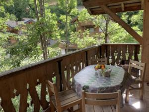a table and chairs on a balcony with a table and fruit at Chalet l'Atelier in Morzine