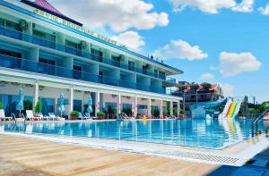 a hotel with a swimming pool in front of a building at Ceti̇n Presti̇ge Resort in Erdek