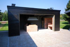 un garaje negro con una pared de ladrillo en Banja Kulaši en Kulaši
